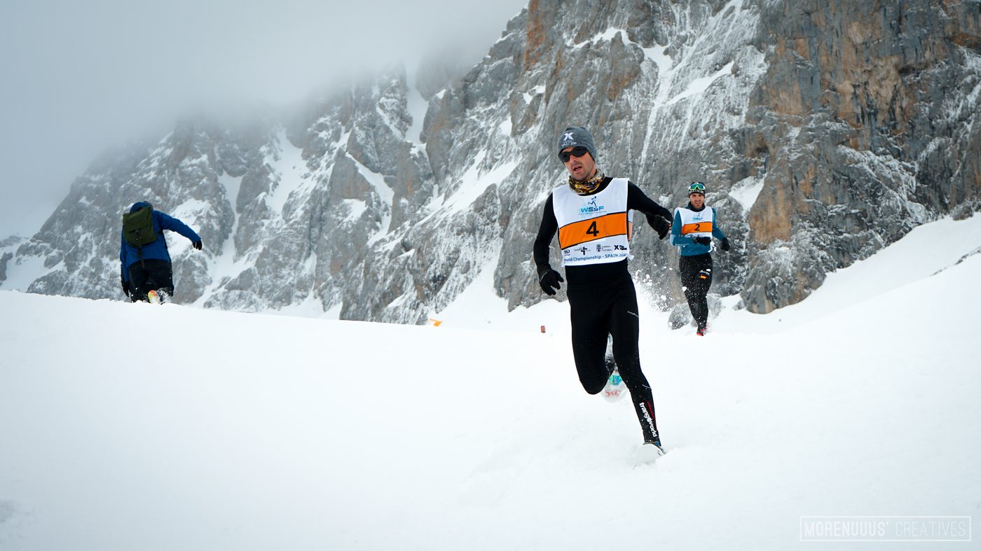 Corredores compitiendo sobre la nieve en alta montaña